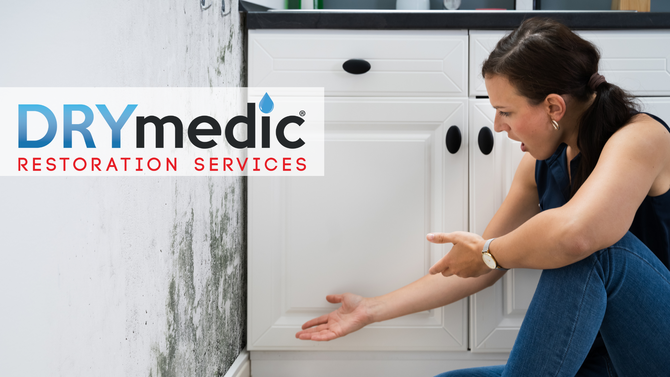 woman pointing to mold spores on wall